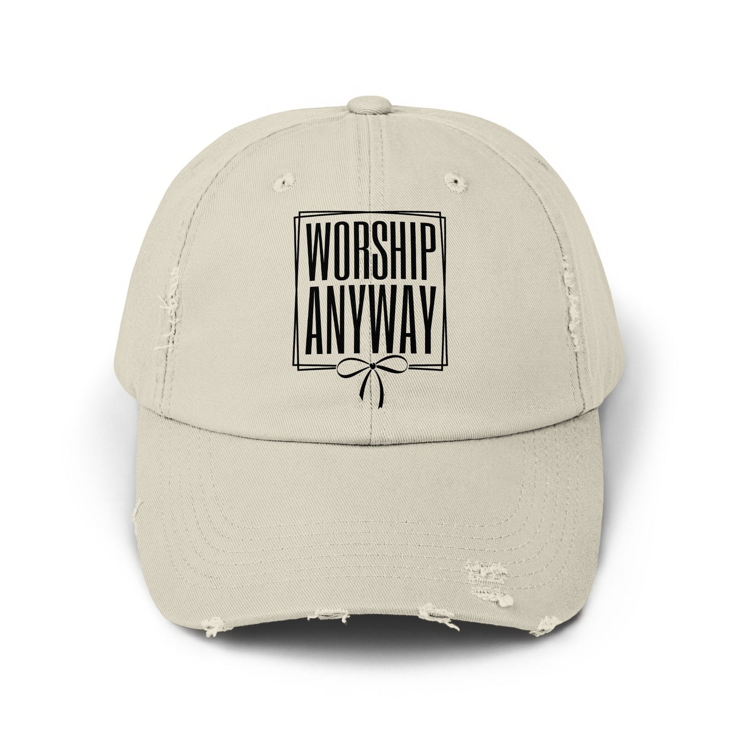 Distressed beige baseball cap with black text "WORSHIP ANYWAY" and a bow design.