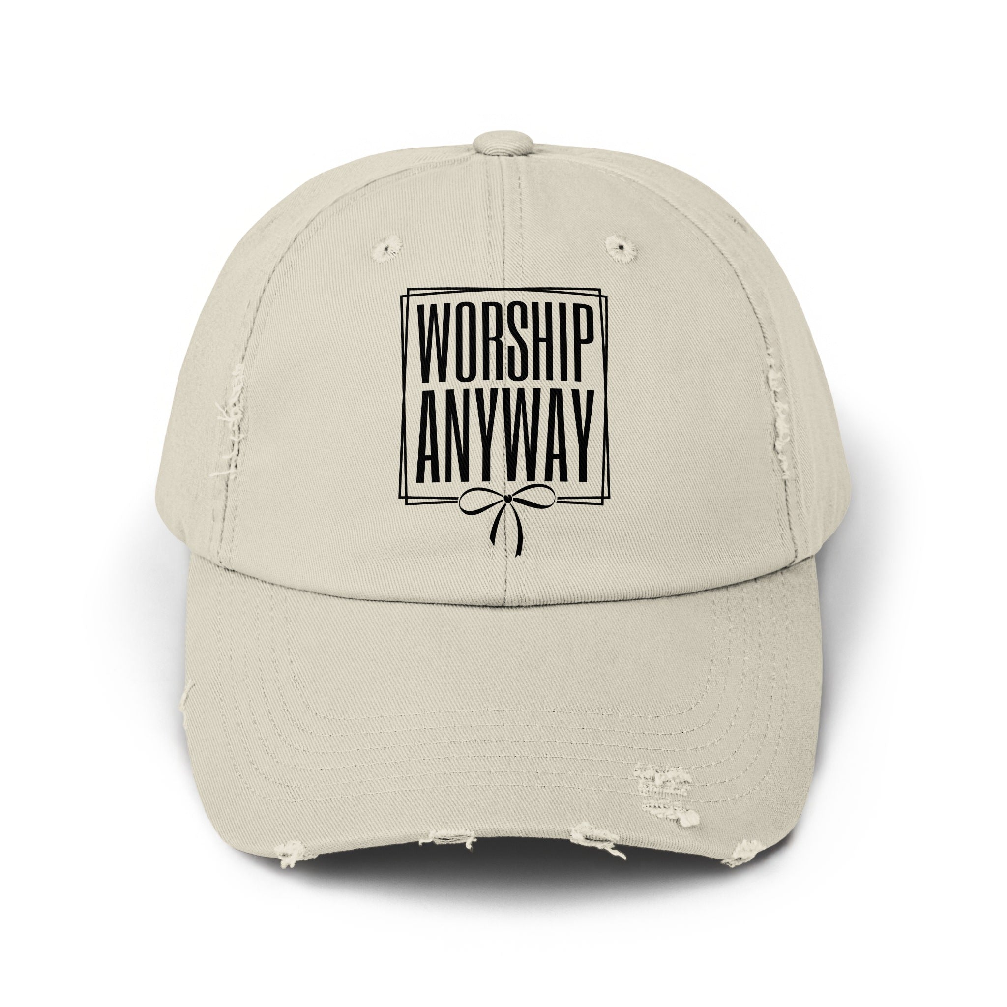 Distressed beige baseball cap with black text "WORSHIP ANYWAY" and a bow design.
