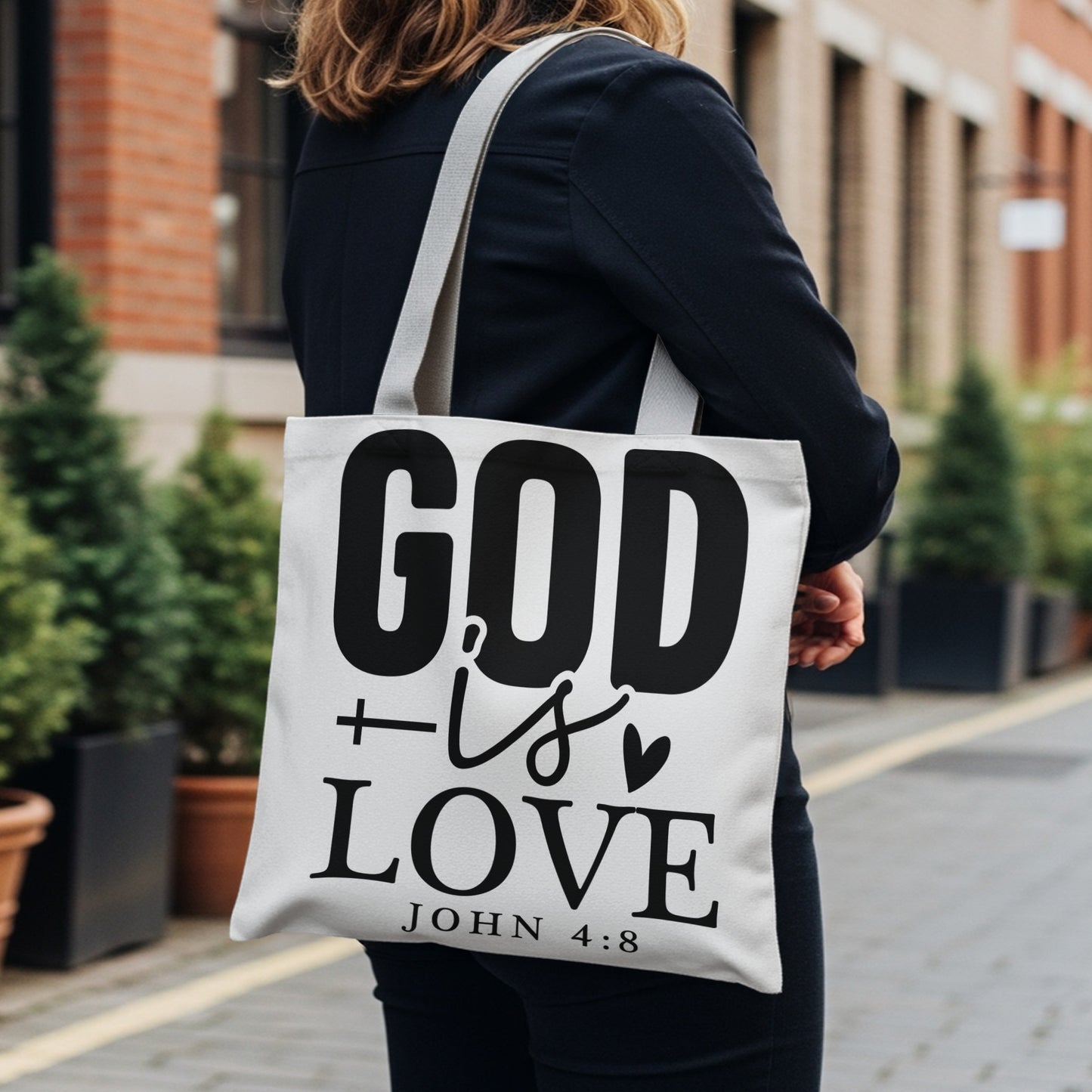 White tote bag with black text "GOD is LOVE" and "JOHN 4:8"
