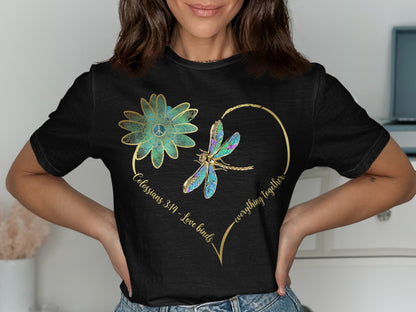 Black t-shirt with gold heart outline, dragonfly, flower, and text "Colossians 3:14 - Love binds everything together."