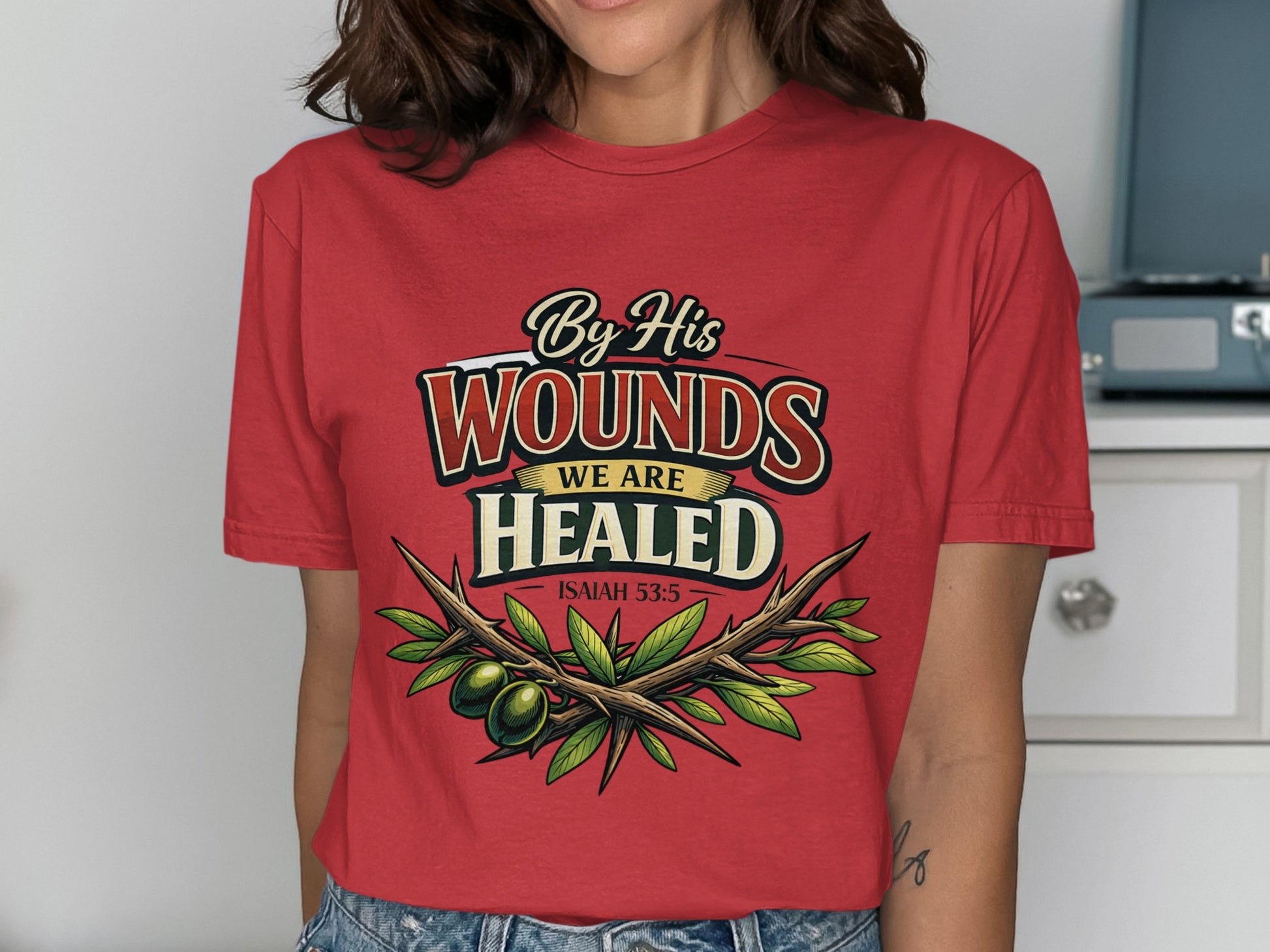 Red t-shirt with "By His Wounds We Are Healed Isaiah 53:5" and olive branch design.