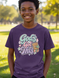 Boy wearing purple t-shirt with "God's Got This" text, teddy bear, and cross graphic.