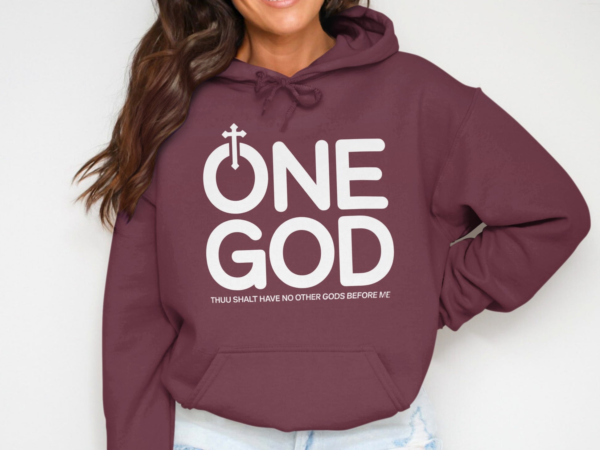 Maroon hoodie with white text "ONE GOD" and a small cross above "ONE".
