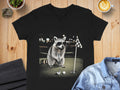 Raccoon wearing sunglasses about to putt a golf ball on a golf course.