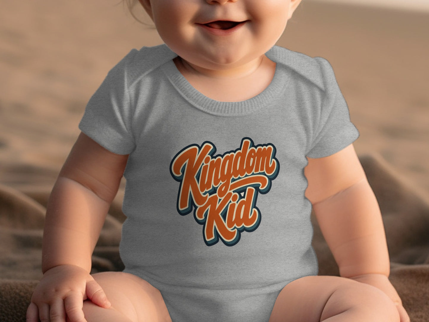 Gray baby onesie with "Kingdom Kid" graphic in orange and blue text.