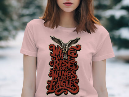 Pale pink t-shirt with a graphic of an eagle and the text "We will rise on wings like eagles".