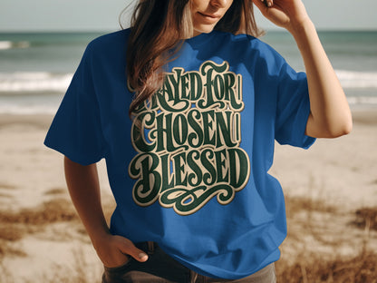 Blue t-shirt with "Prayed For Chosen Blessed" text on beach background.