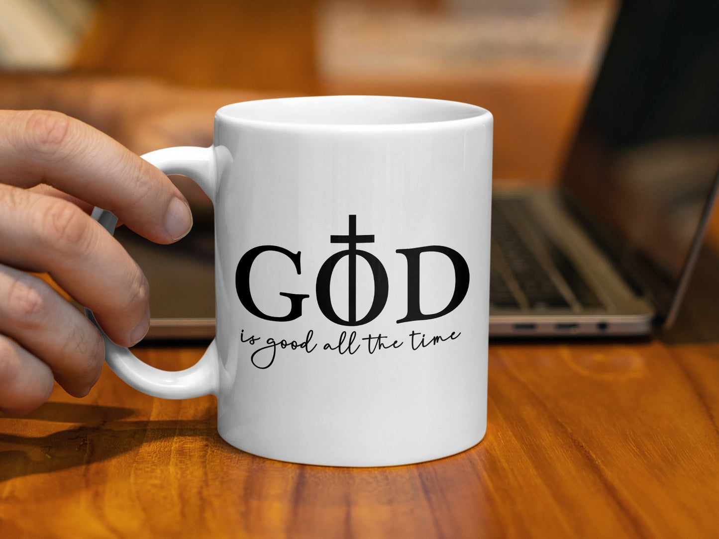 White mug with black text "GOD is good all the time" and a cross.