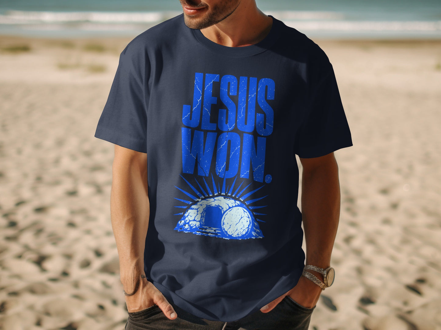 Dark blue t-shirt with blue "JESUS WON" text, tomb, and sunburst graphic.