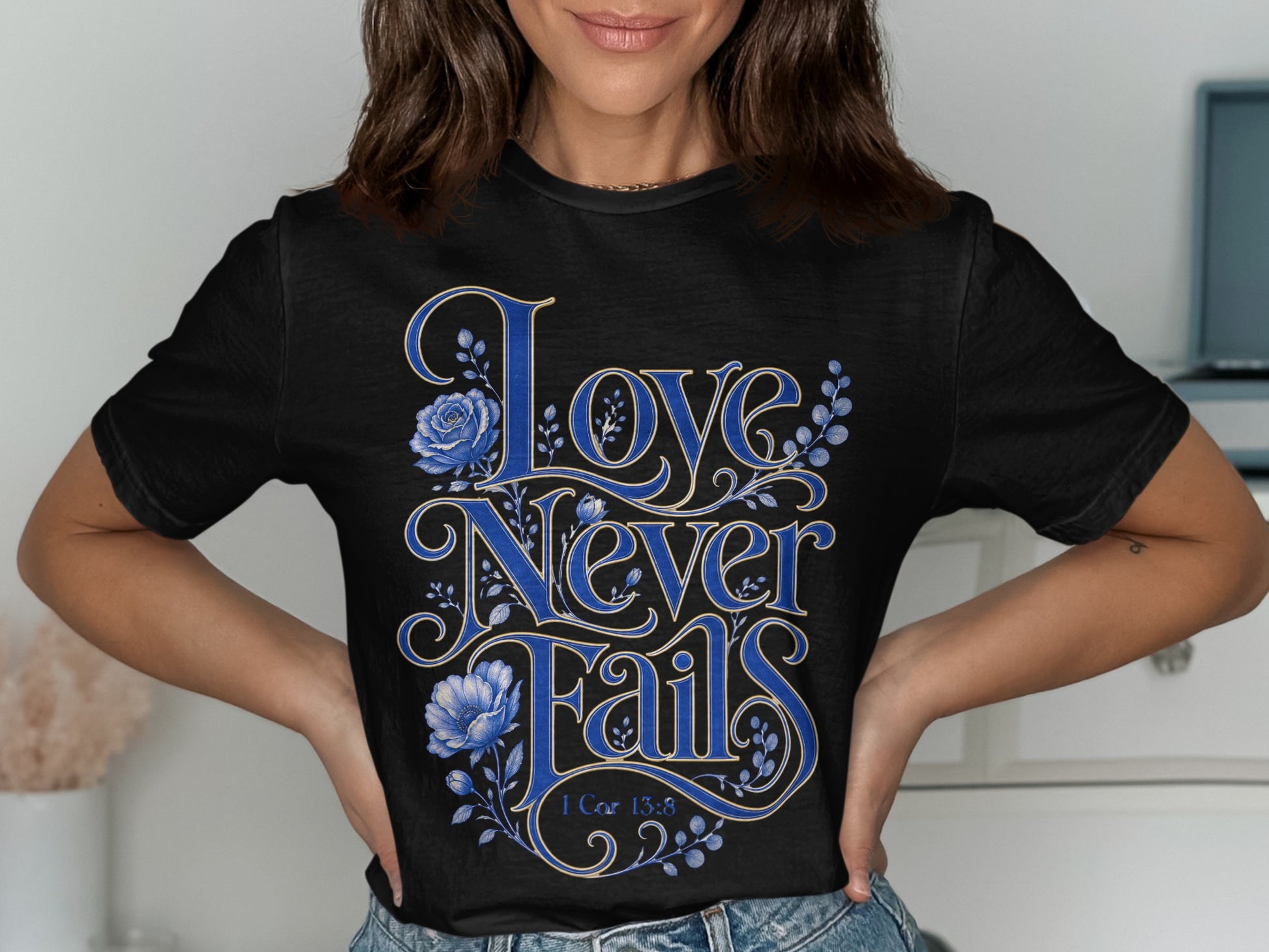 Black t-shirt with "Love Never Fails" and "1 Cor 13:8" in blue lettering.