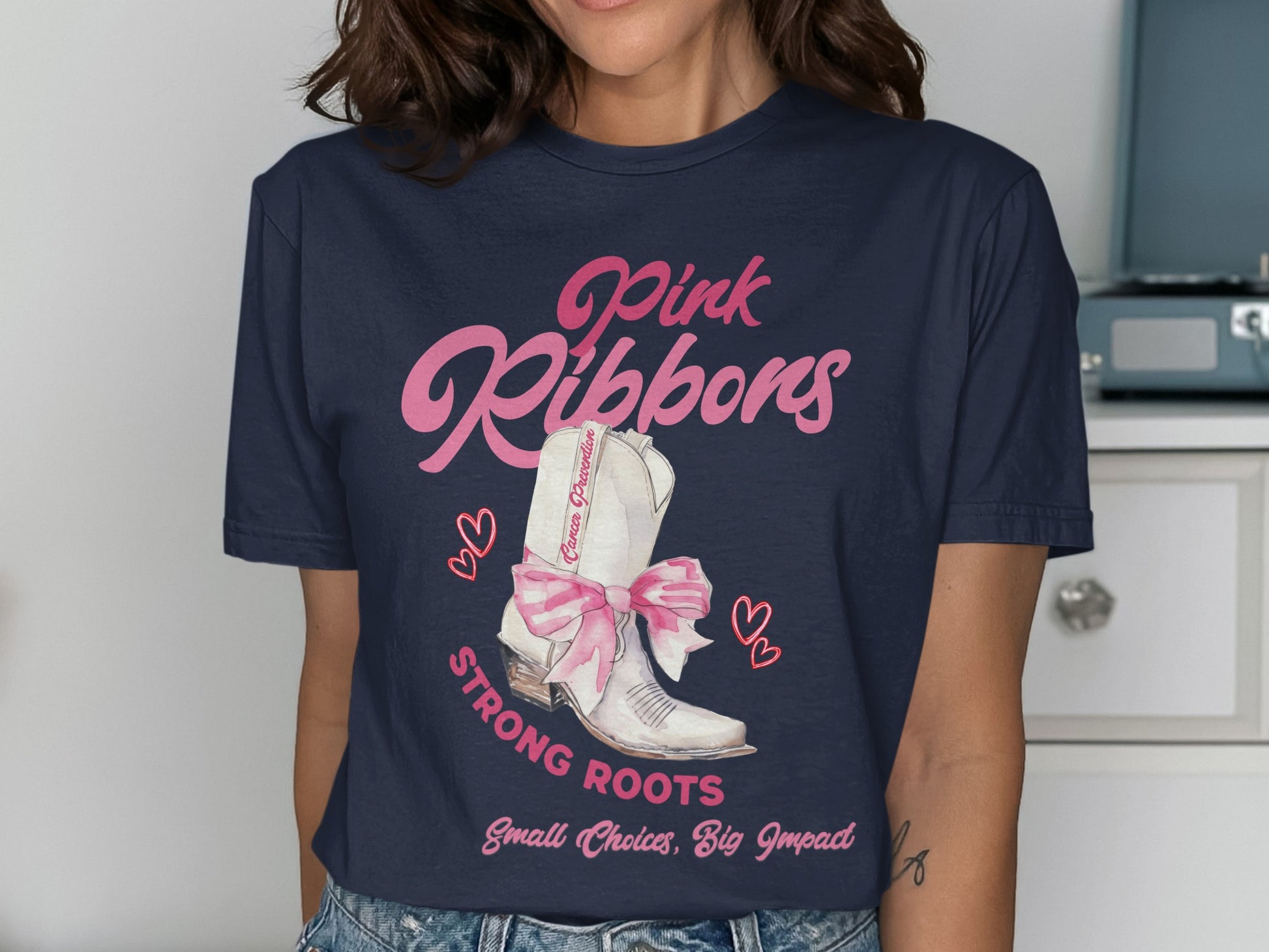 Navy t-shirt with "Pink Ribbons" and a white cowboy boot with pink bow.
