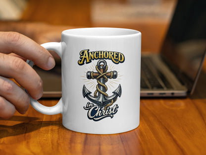 White mug with "Anchored in Christ" text and an anchor cross design.