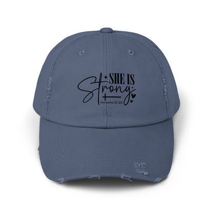 Distressed blue baseball cap with "SHE IS Strong" and "Proverbs 31:25" text.