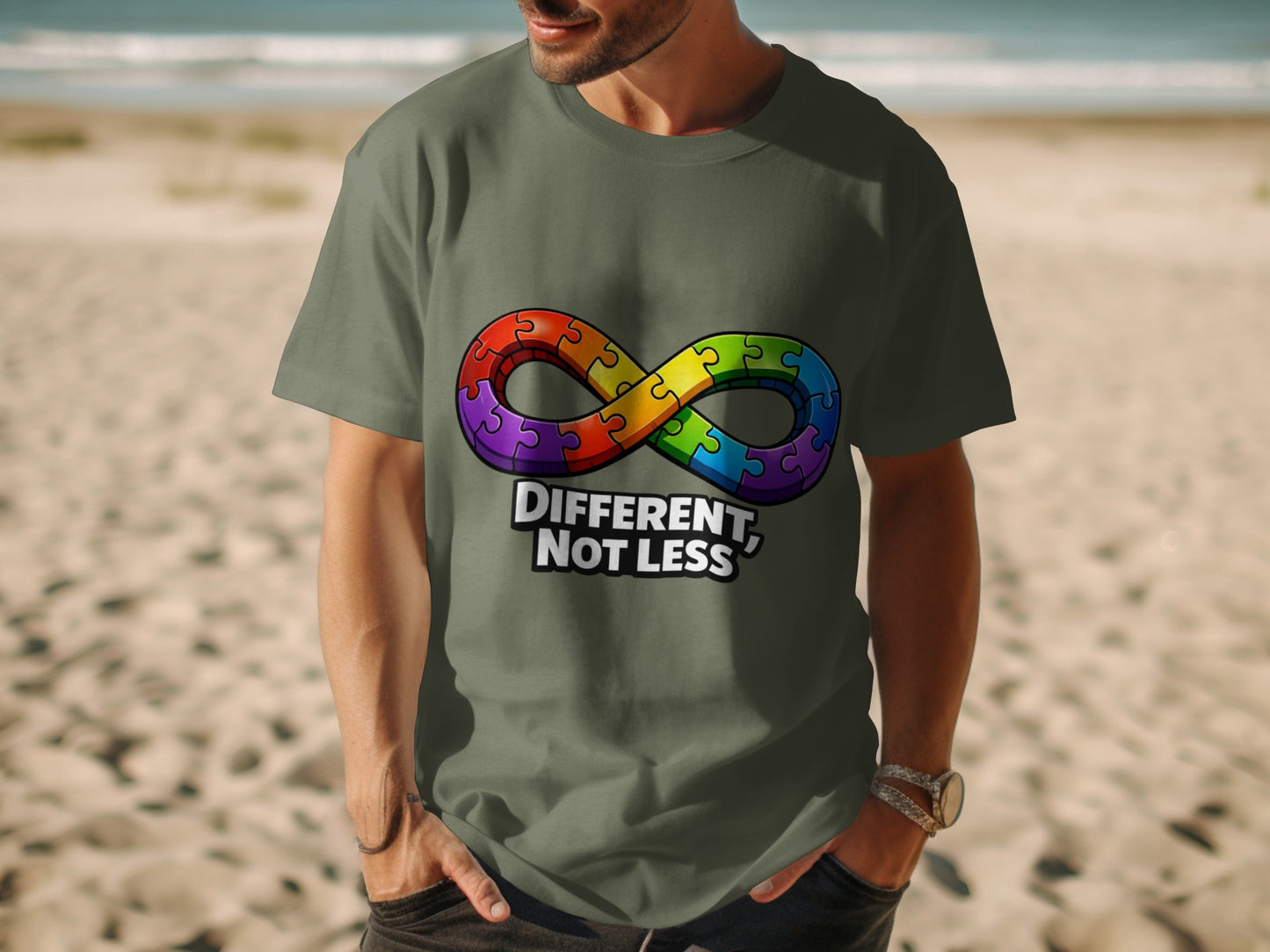 Man in grey t-shirt with rainbow puzzle infinity symbol and "Different, Not Less" text.