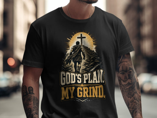 Black t-shirt graphic with a man walking towards a cross with text "GOD'S PLAN. MY GRIND."