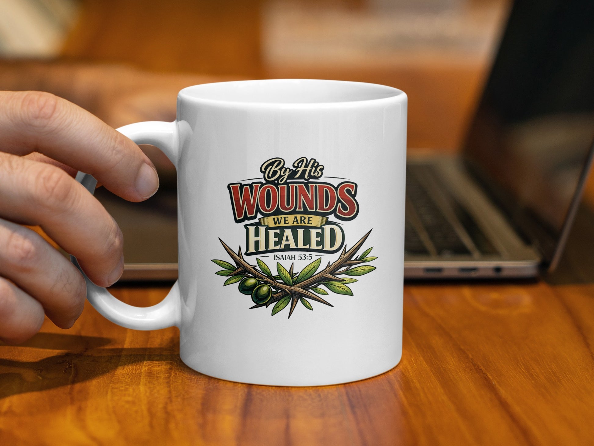 White mug with "By His Wounds We Are Healed" text and thorny branch.