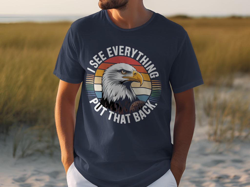 Dark blue t-shirt with an eagle and text saying "I SEE EVERYTHING PUT THAT BACK."