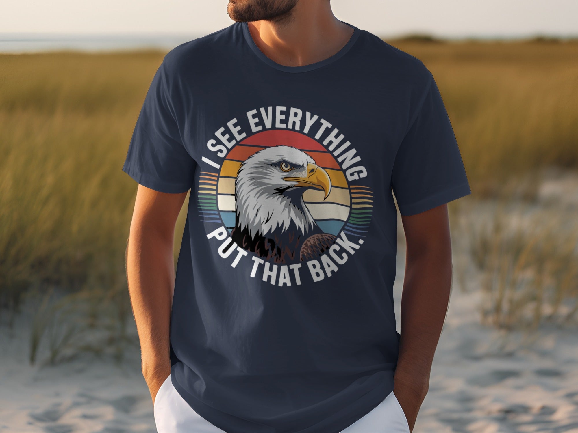 Dark blue t-shirt with an eagle and text saying "I SEE EVERYTHING PUT THAT BACK."