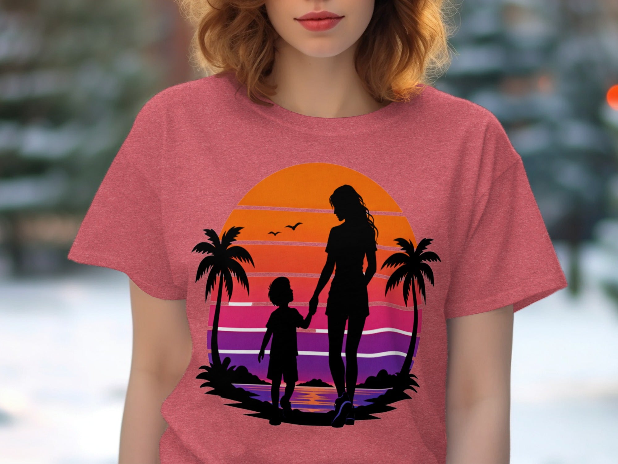 Silhouette of mother and child holding hands on a beach at sunset.