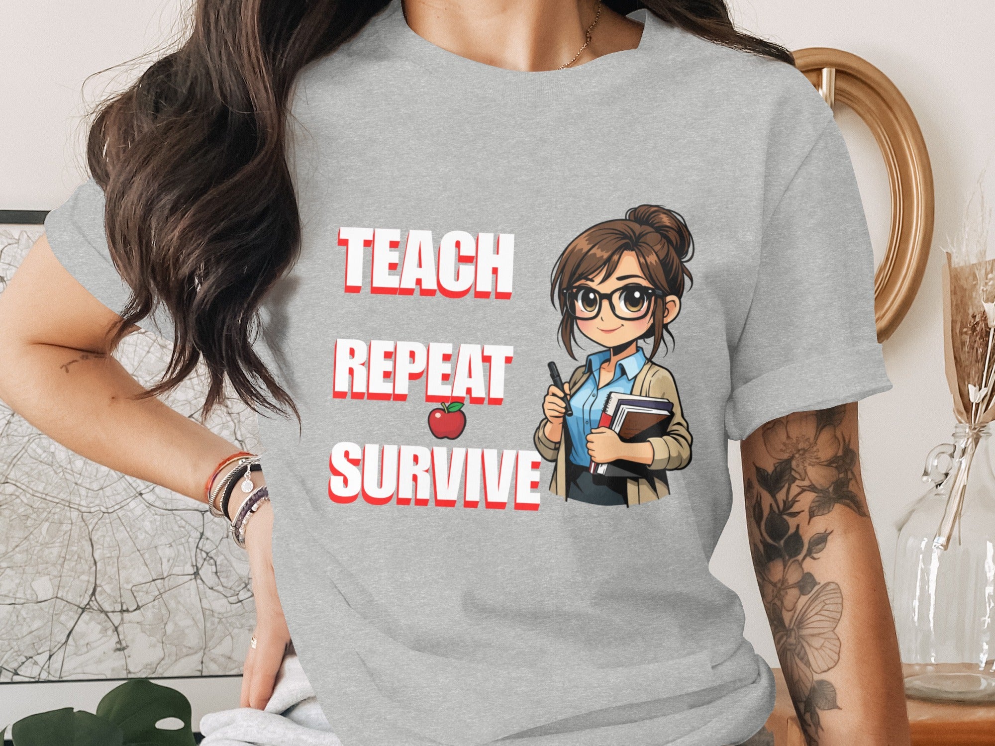 Grey t-shirt with "TEACH REPEAT SURVIVE" text and cartoon teacher illustration.