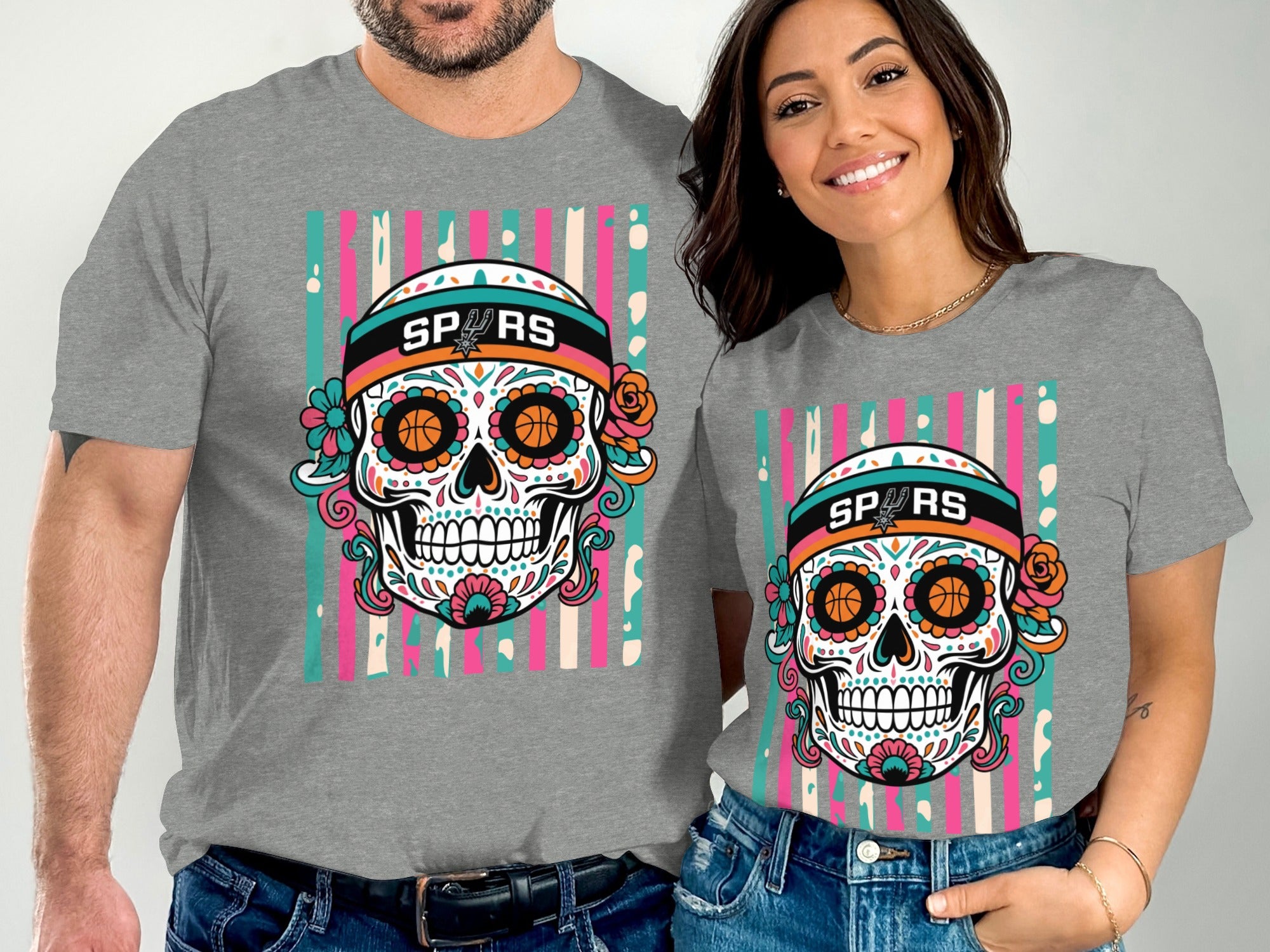 Men's and women's gray t-shirts with a colorful sugar skull graphic and "SPURS" text.