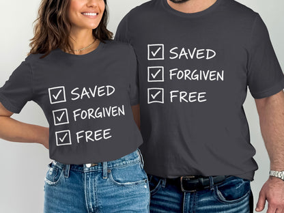 Two dark grey t-shirts with white text: "SAVED", "FORGIVEN", "FREE".