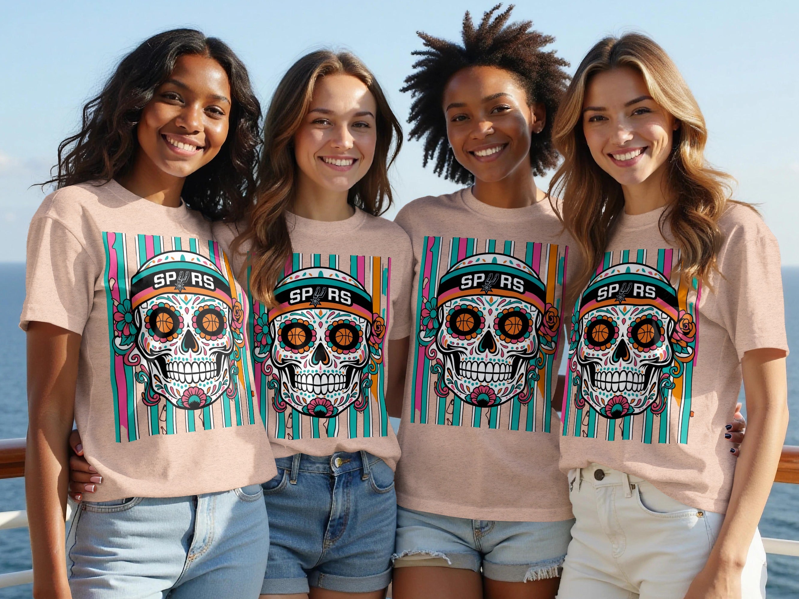 Four women smile wearing matching peach t-shirts with a San Antonio Spurs sugar skull graphic.