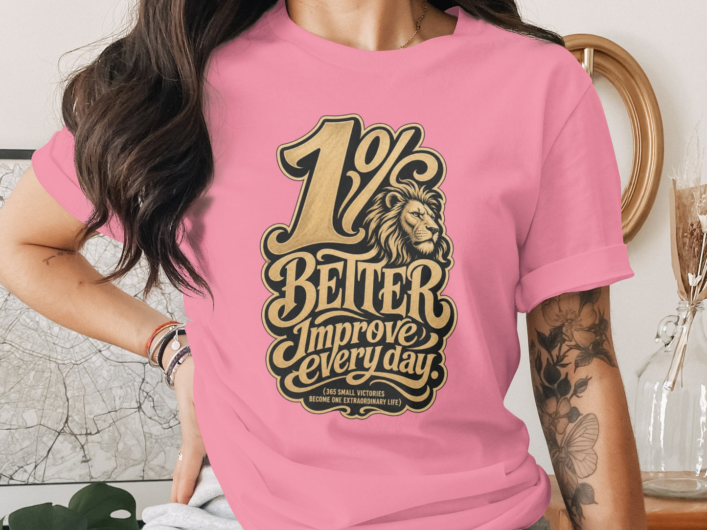 Pink t-shirt with "1% BETTER Improve every day" text and lion graphic.