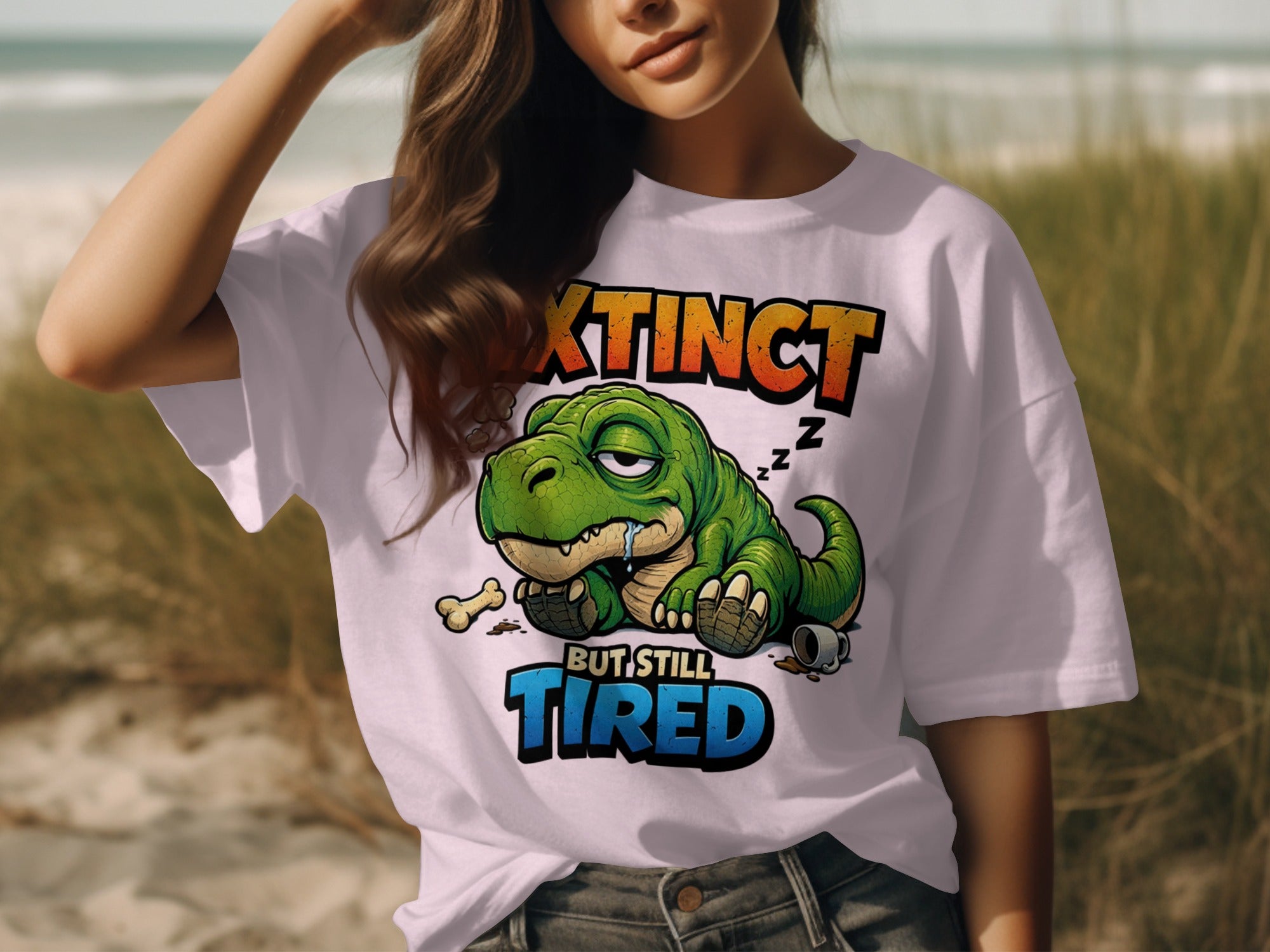 White t-shirt with graphic of sleeping dinosaur and text "Extinct But Still Tired".