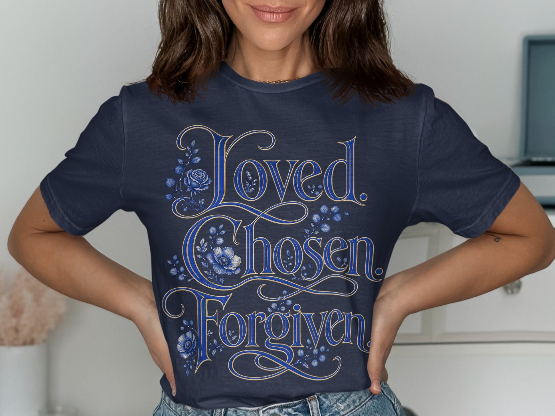 Navy t-shirt with "Loved. Chosen. Forgiven." text and blue floral accents.
