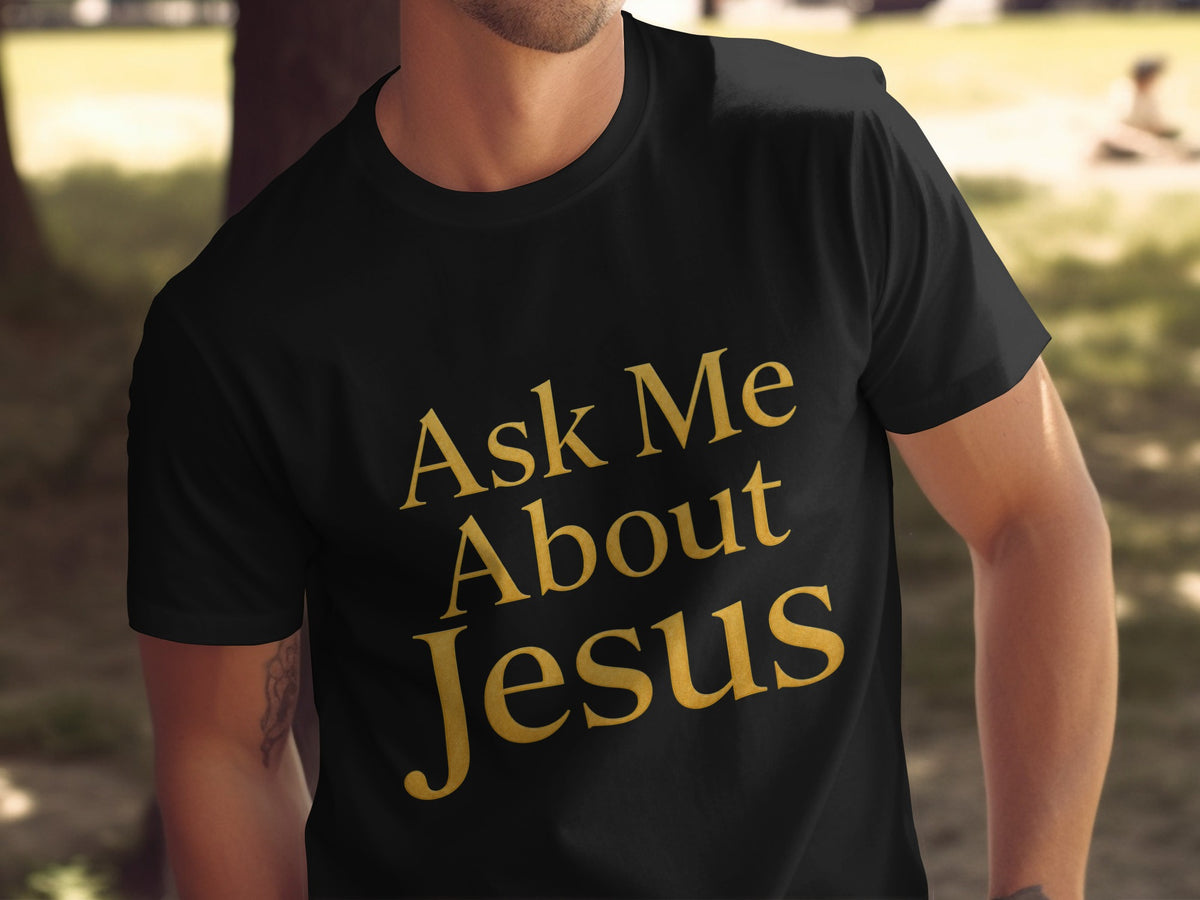 Black t-shirt with gold text that reads "Ask Me About Jesus."