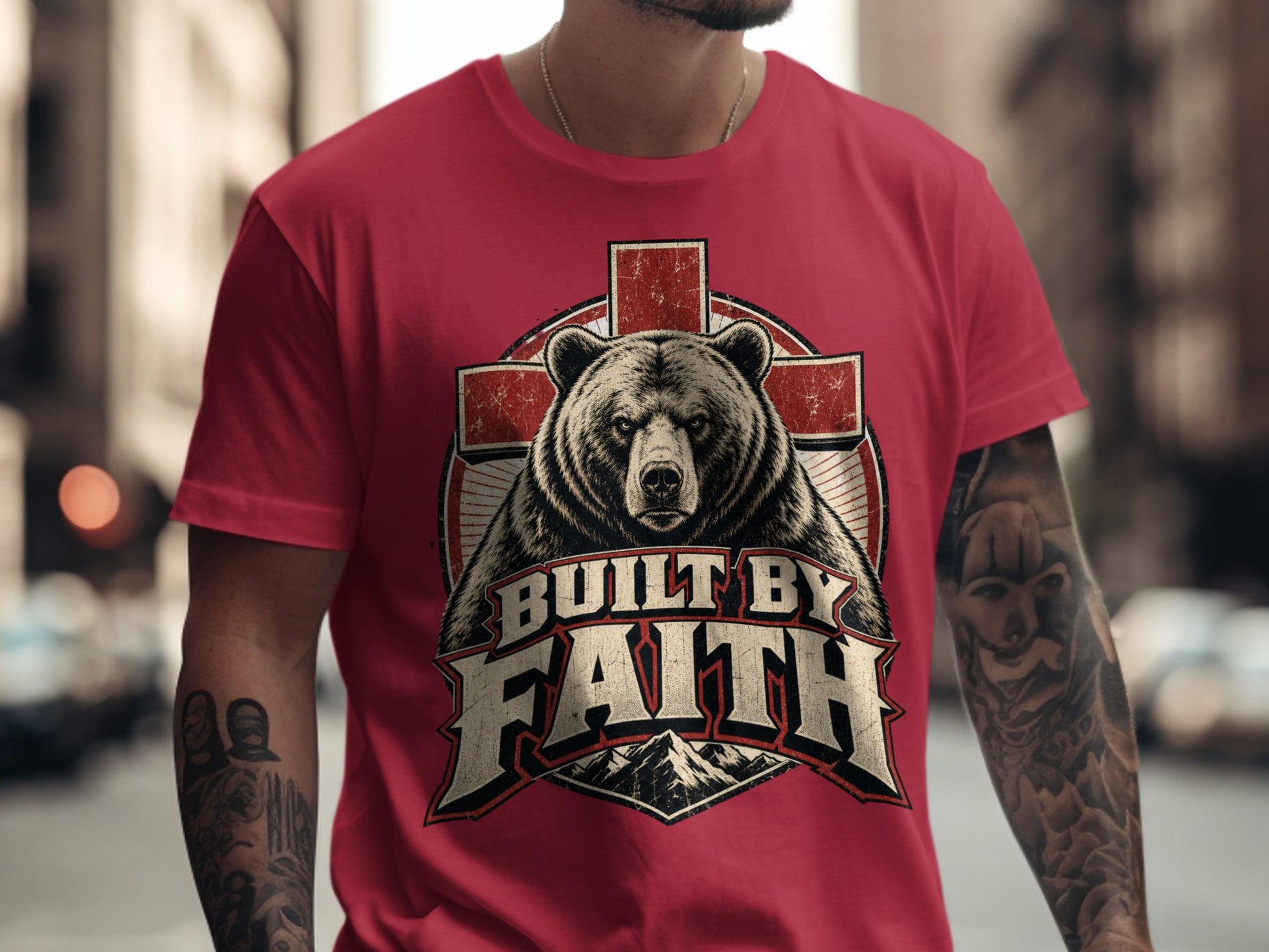 Red t-shirt with a graphic of a bear, cross, and mountains, reading "Built by Faith".