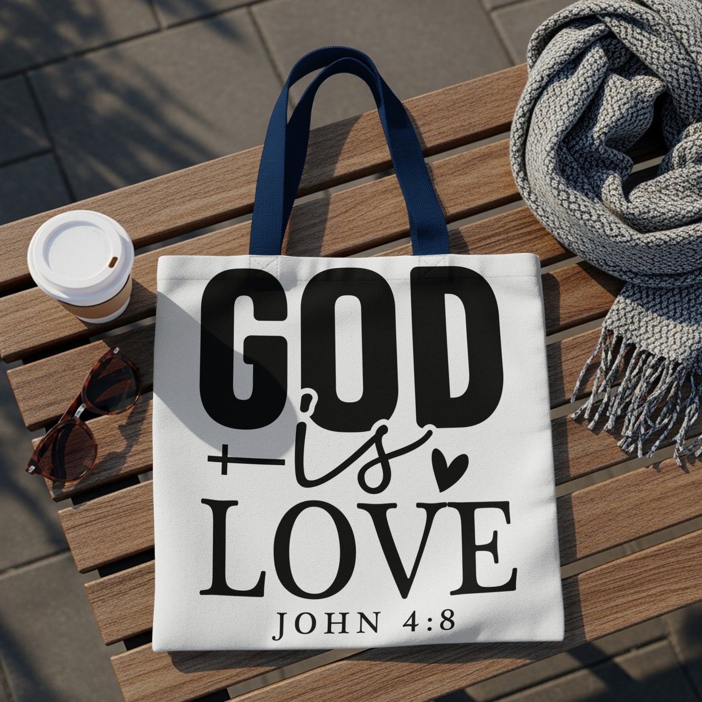 White tote bag with "GOD is LOVE JOHN 4:8" text, and blue handles.
