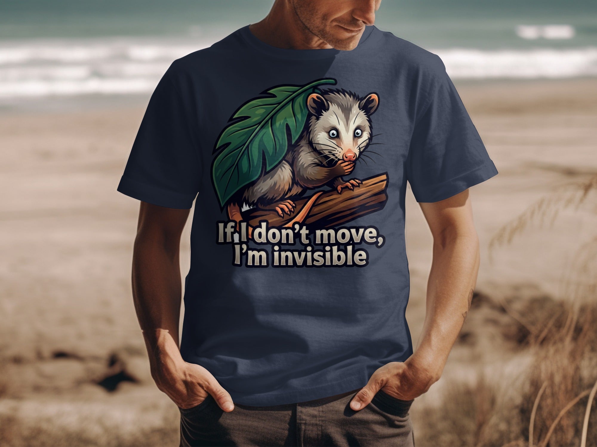 Navy t-shirt with an opossum hiding behind a leaf and text "If I don't move, I'm invisible."