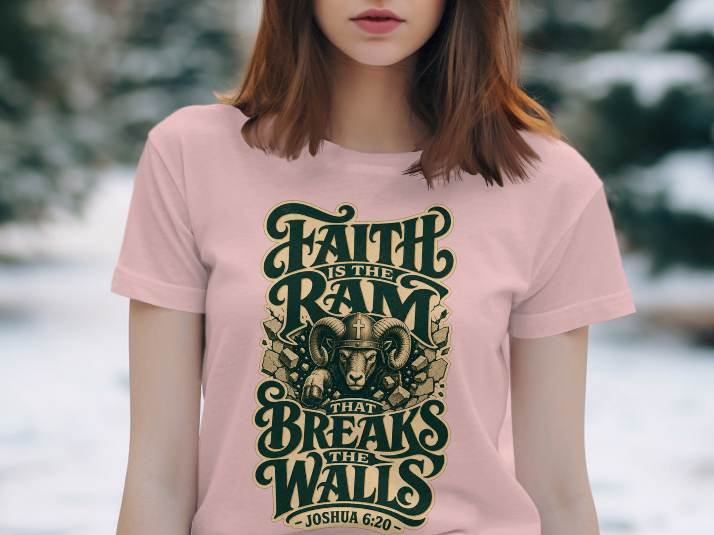 Pink t-shirt with a graphic of a ram breaking walls, text "FAITH IS THE RAM THAT BREAKS THE WALLS - JOSHUA 6:20".