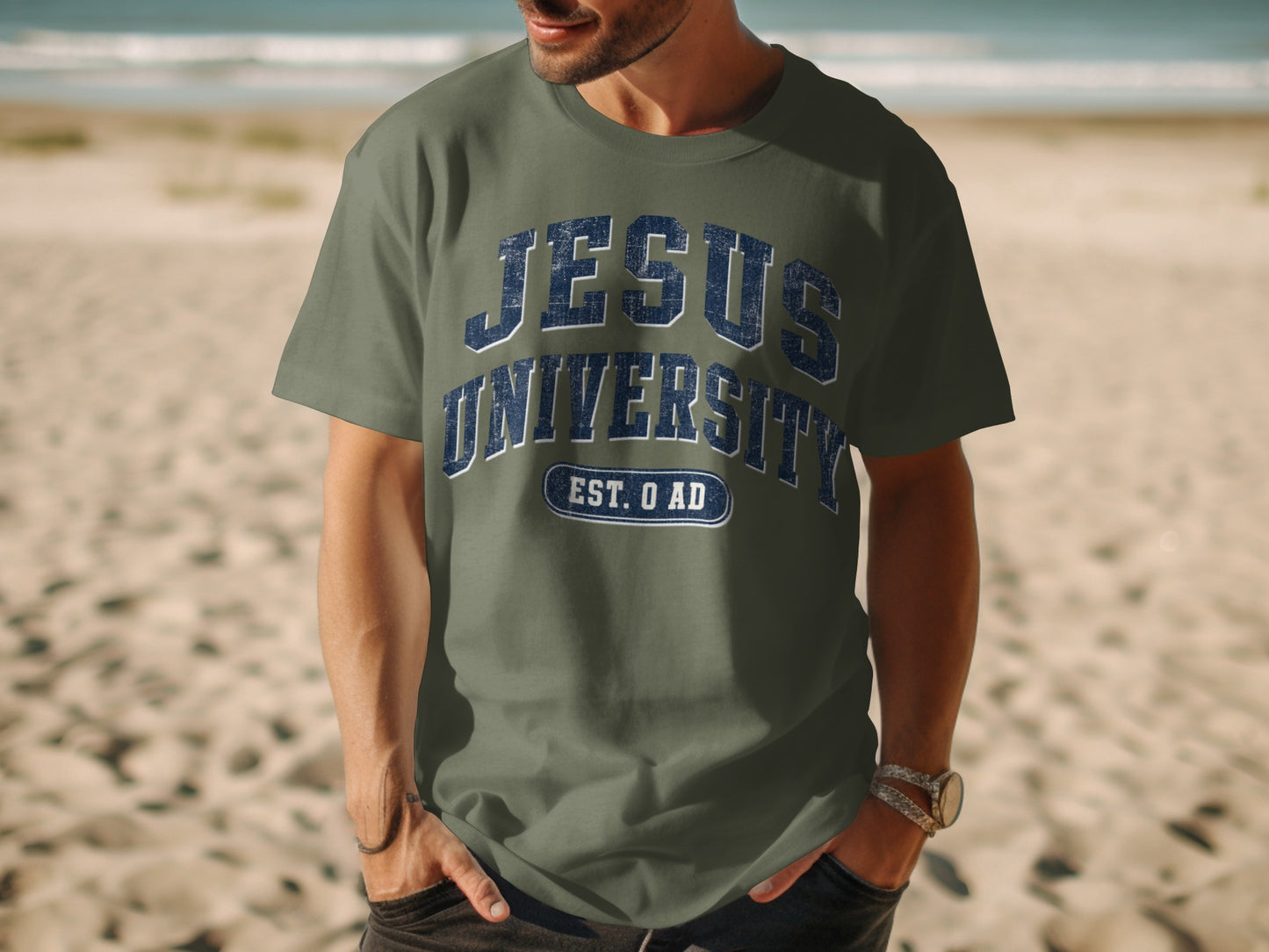 Green t-shirt with "JESUS UNIVERSITY EST. 0 AD" text on beach background
