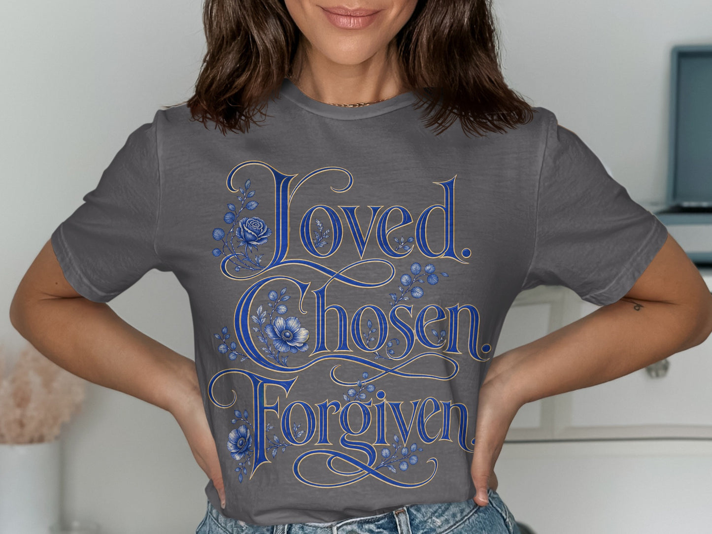 Dark grey t-shirt with "Loved. Chosen. Forgiven." text and blue floral accents.
