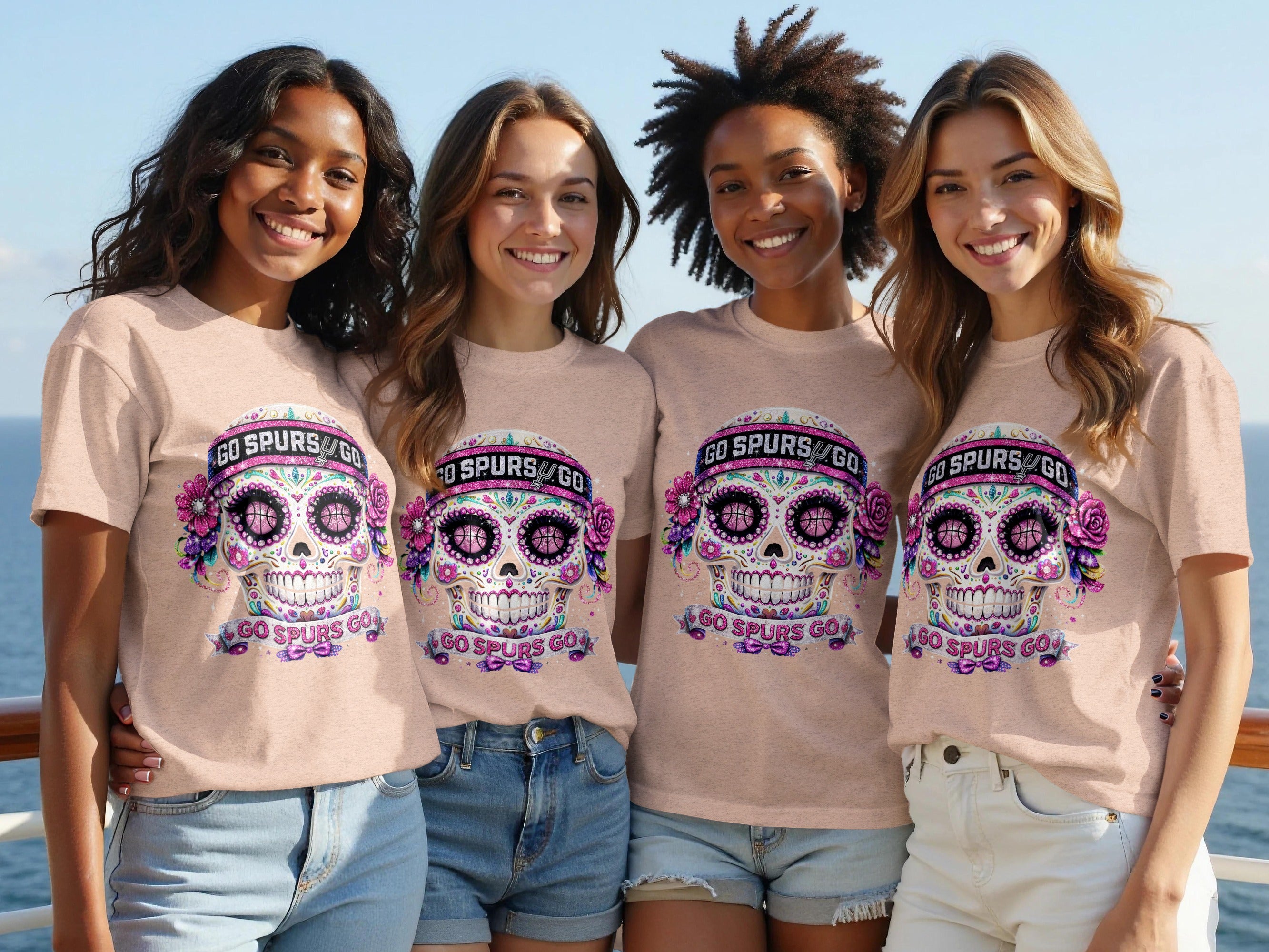 Four smiling young women in peach shirts featuring a skull graphic with "GO SPURS GO".