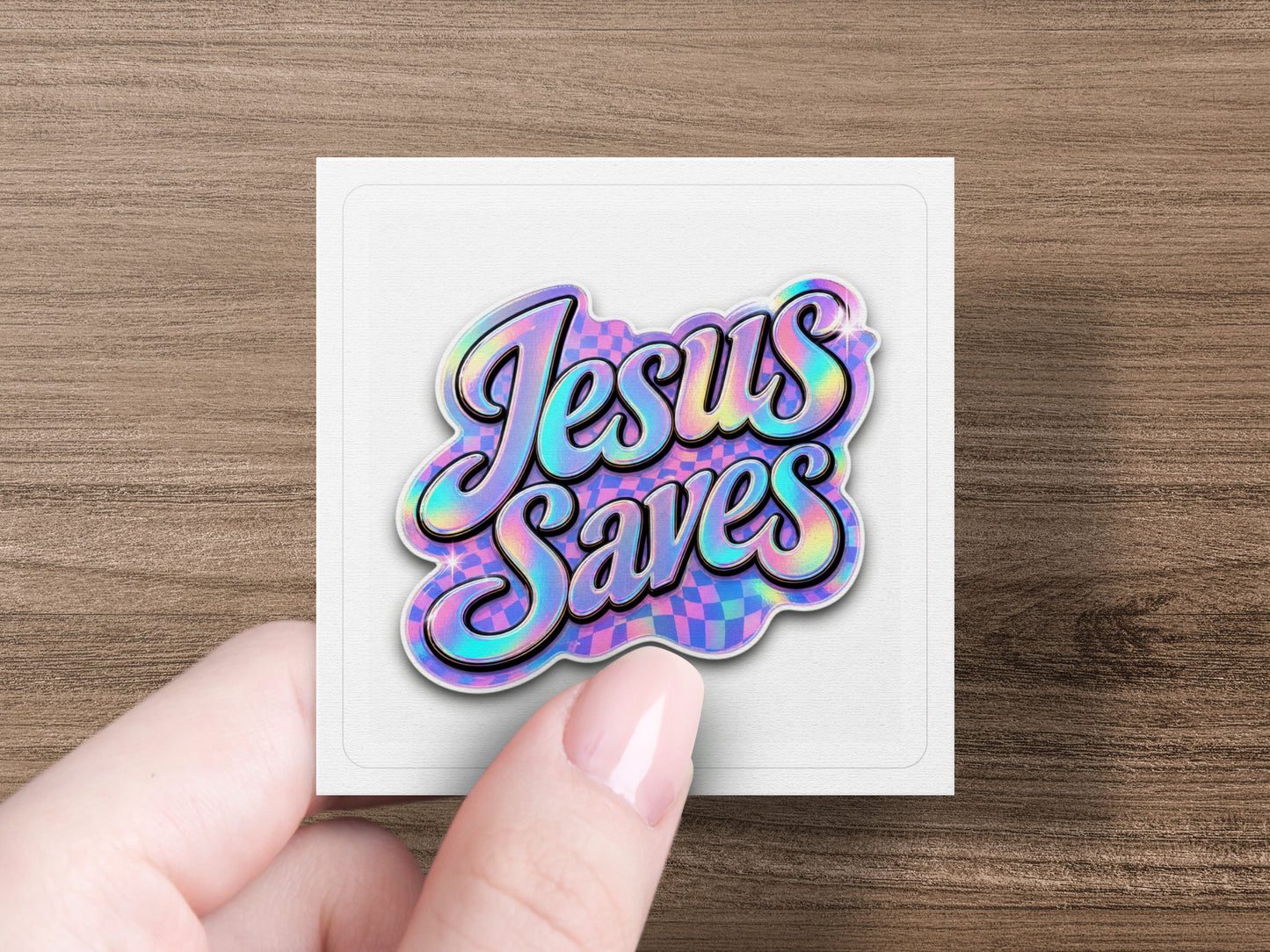 Holographic sticker with "Jesus Saves" in cursive on a checkered background.