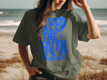Olive green t-shirt with blue text "KEEP THE FAITH" and mountain graphic.