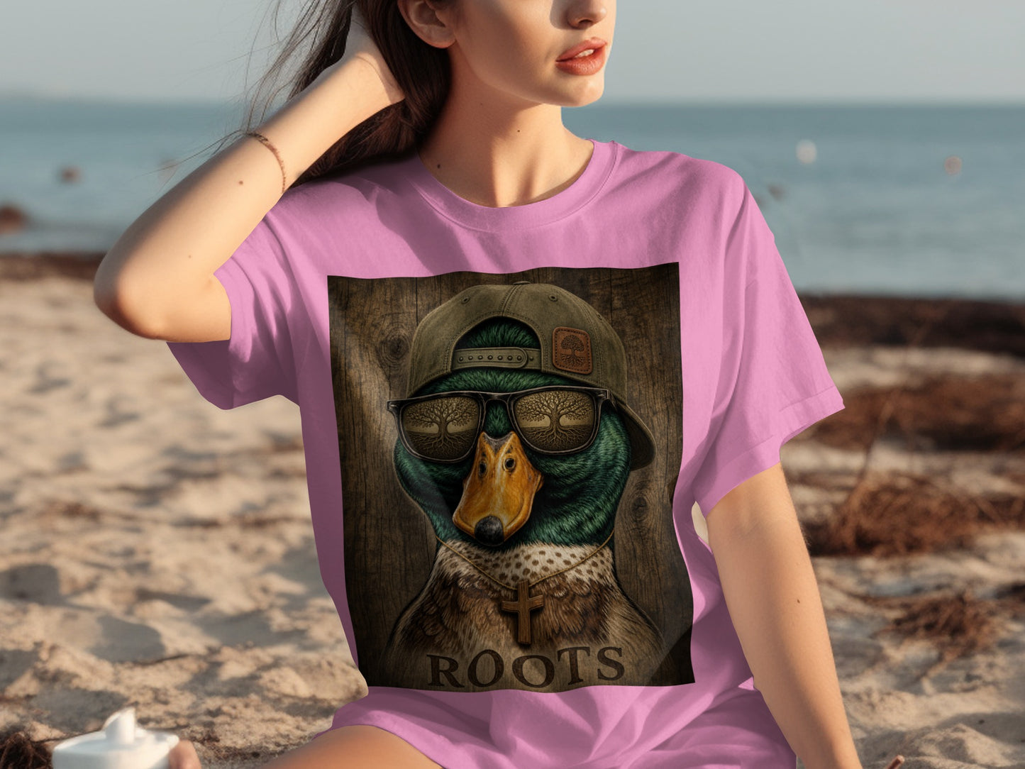 Pink t-shirt with a graphic of a duck wearing a backwards cap, sunglasses, and a cross necklace.