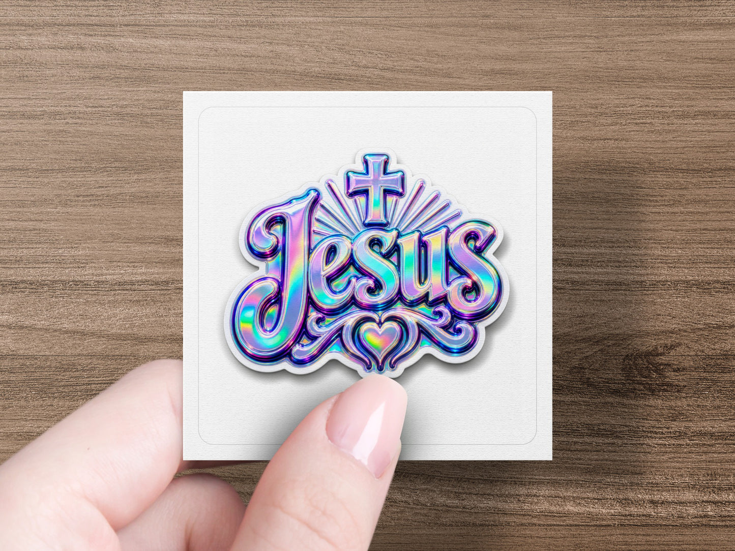 Holographic "Jesus" lettering with heart and cross design on a white square.