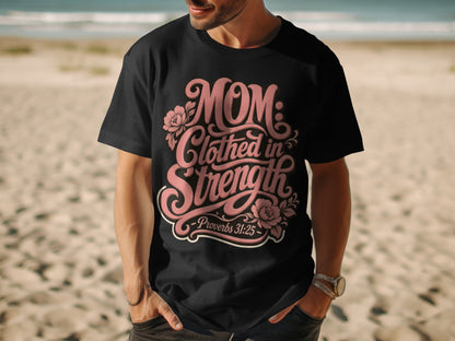 Black t-shirt with pink text "MOM: Clothed in Strength - Proverbs 31:25" and floral accents.