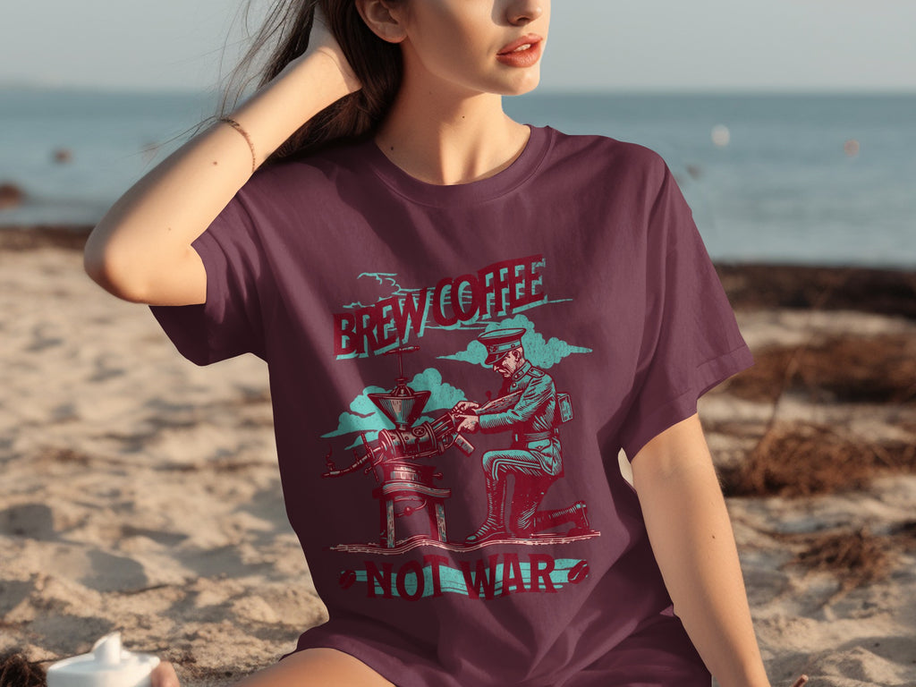 Maroon t-shirt graphic of soldier operating coffee grinder with text "Brew Coffee Not War".