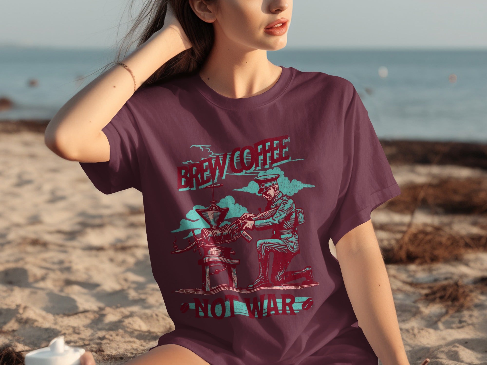 Maroon t-shirt graphic of soldier operating coffee grinder with text "Brew Coffee Not War".