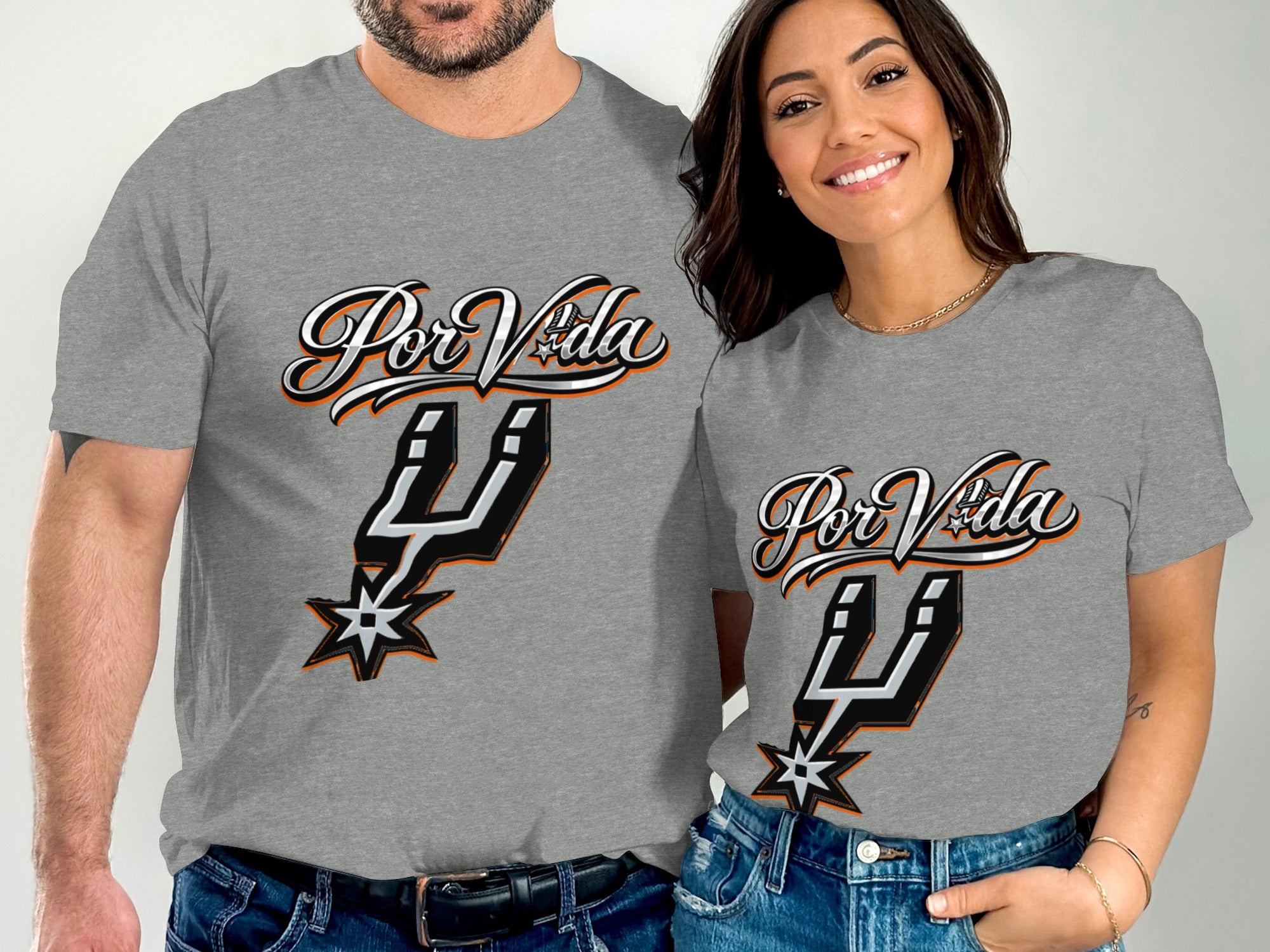 Couple wearing grey t-shirts with "Por Vida" and San Antonio Spurs logo.
