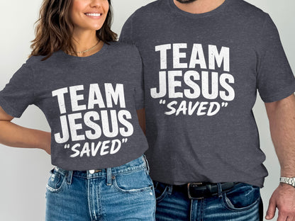 Two people in dark gray t-shirts with white text "TEAM JESUS 'SAVED'".