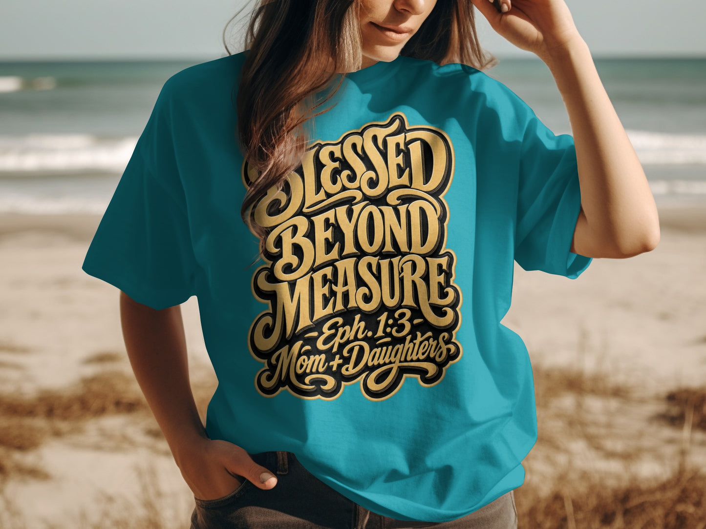 Teal t-shirt with "Blessed Beyond Measure - Eph. 1:3 - Mom + Daughters" text on beach background.