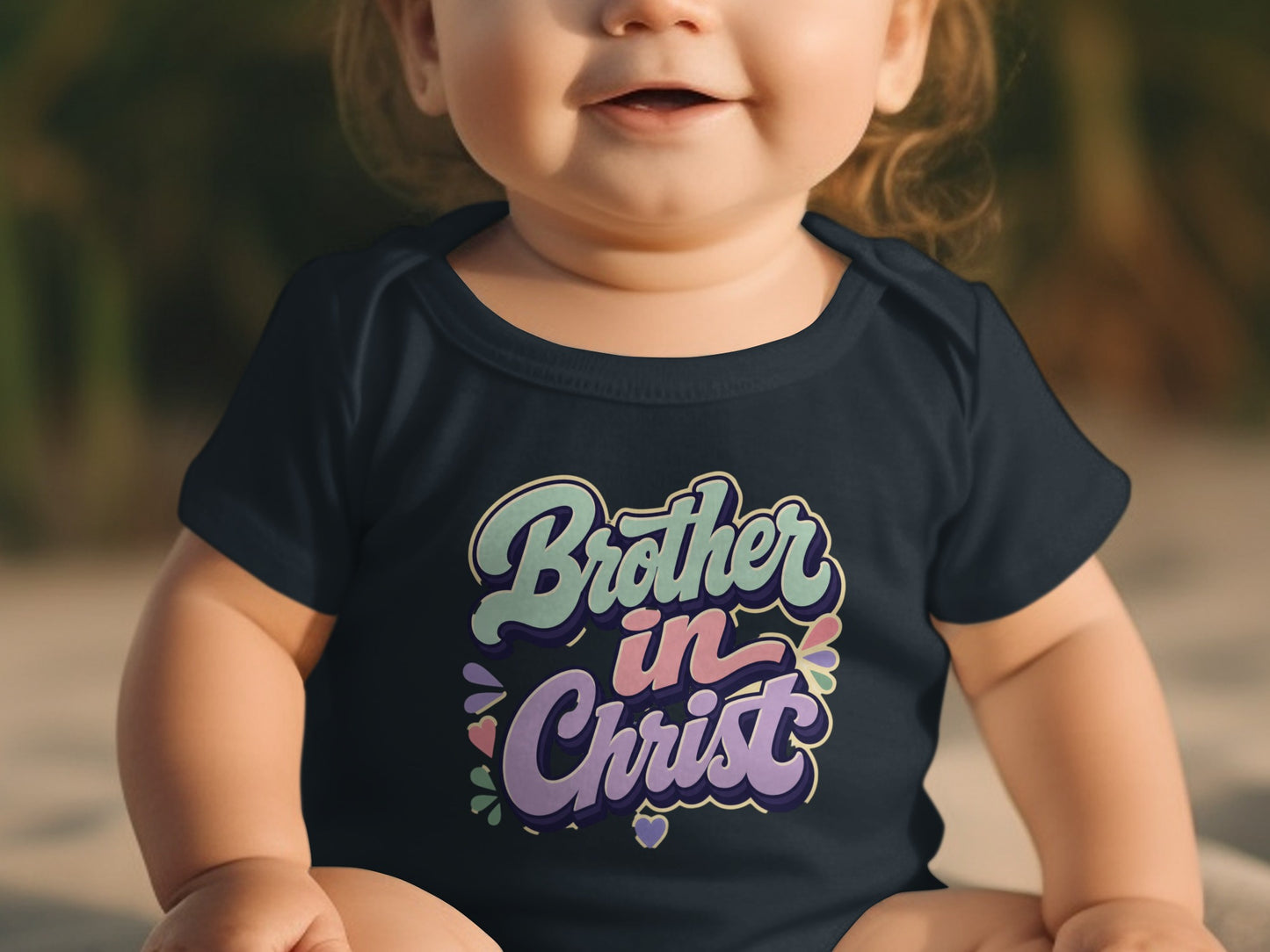 Dark blue baby onesie with "Brother in Christ" text in pastel colors.