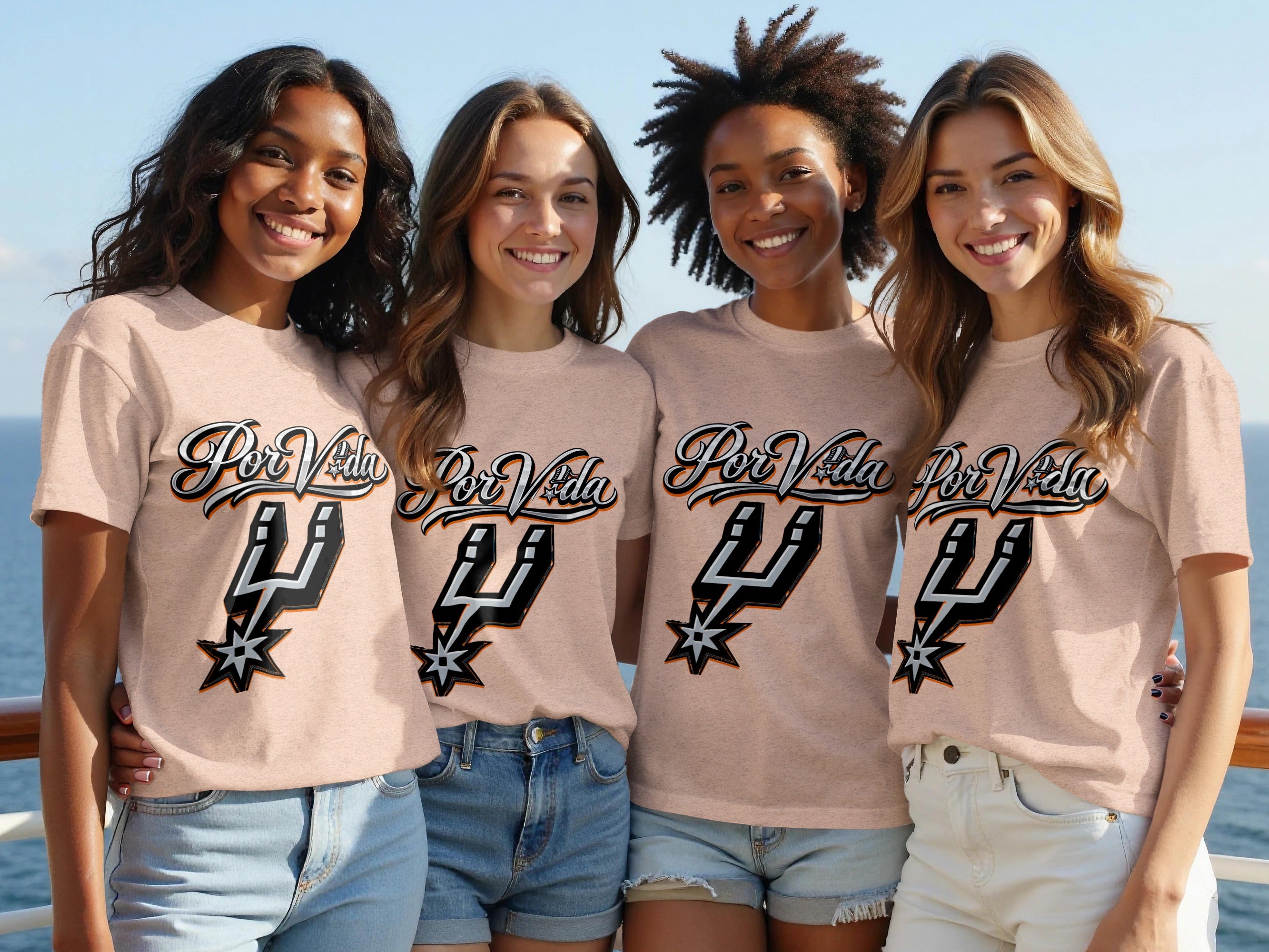 Four smiling young women wear matching peach t-shirts with "Por Vida" and Spurs logo graphic.